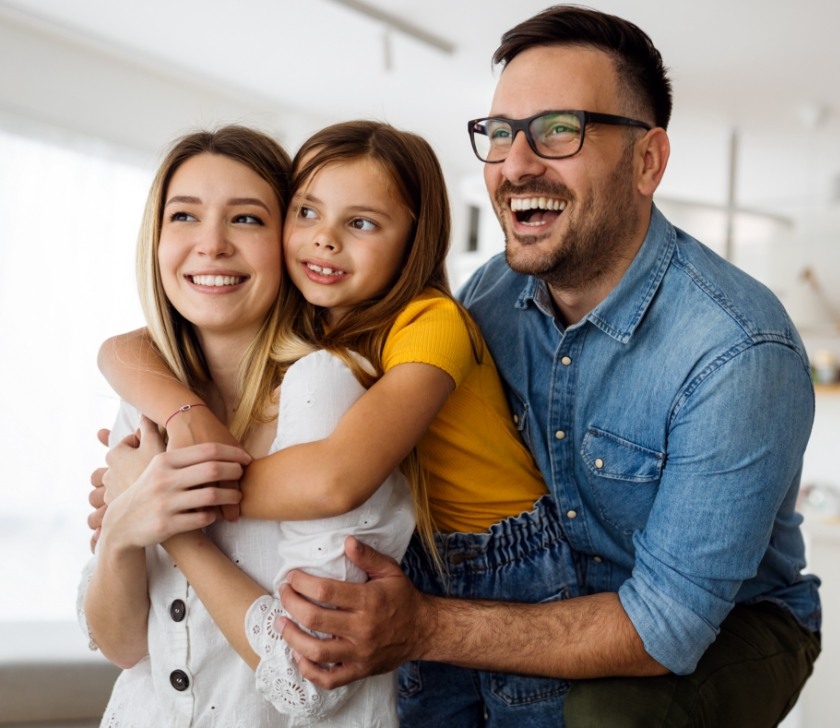 Mother father and child smiling in dental office