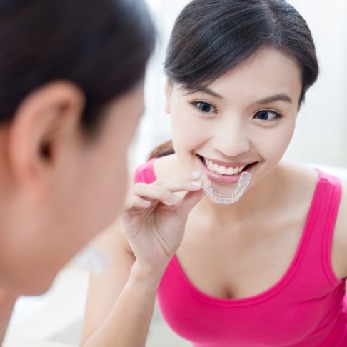 Woman placing Invisalign clear aligner tray