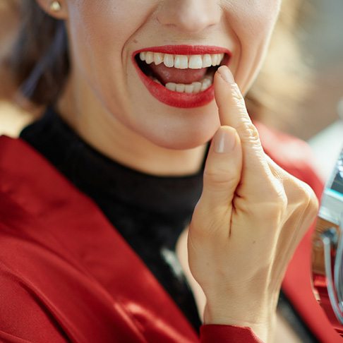 Woman pointing to dental crown in Brookfield