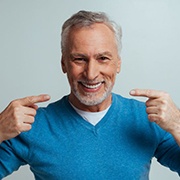 Smiling senior man pointing at his teeth
