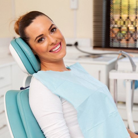 Female dental patient smiling in dental chair