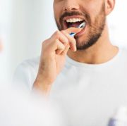 Man in white shirt brushing his teeth