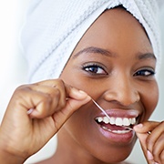 Woman smiling while flossing her teeth