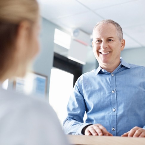 Man discussing the cost of dental implants with dentistry team member