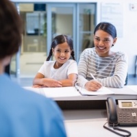 Mother and child filling out dental insurance forms