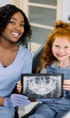 Dental team member and dental patient smiling together