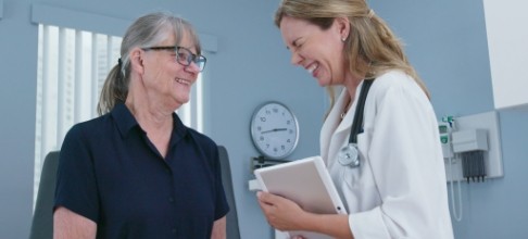 Dentist laughing with older dental patient