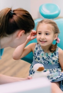 Dentist smiling at young dental patient