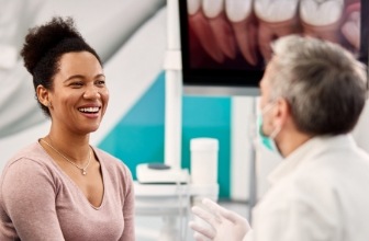 Dentist and dental patient laughing together