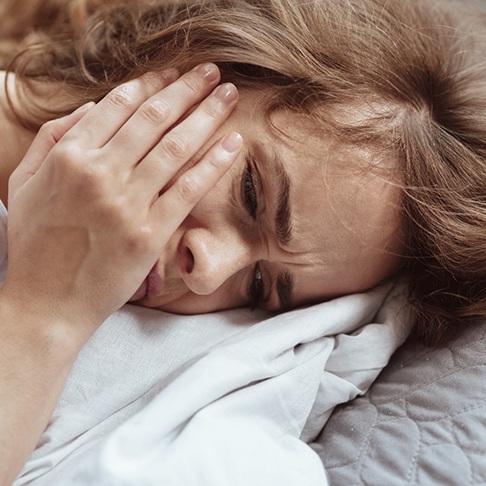 woman with toothache in bed before root canal treatment in Brookfield