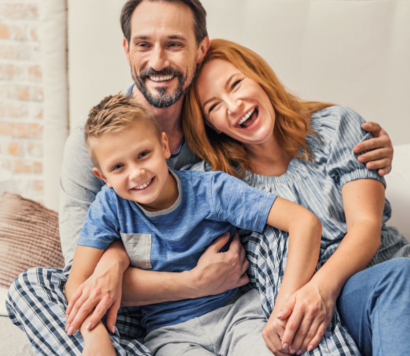 Parents and child smiling after receiving dental services