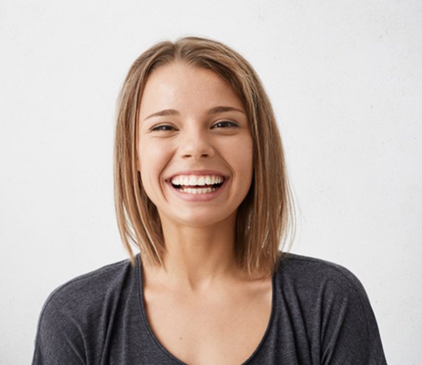 smiling young woman with veneers in Brookfield 
    What Are Dental Veneers?
