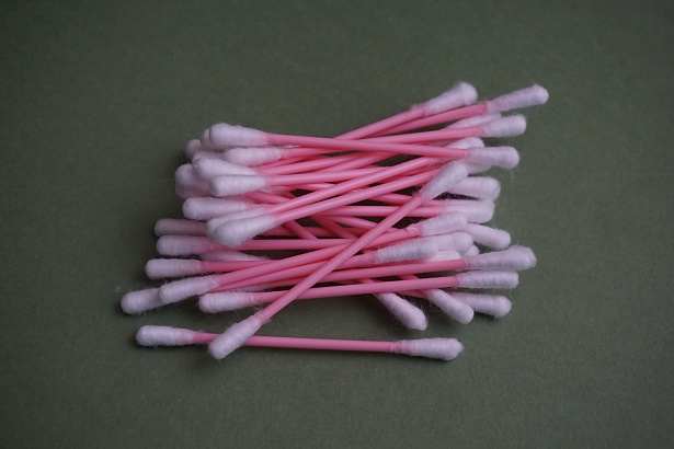 pink cotton swabs on gray background