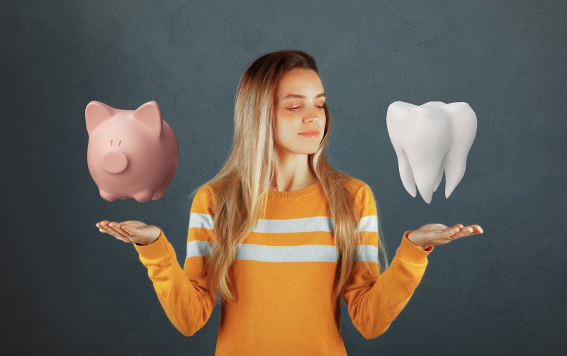 A woman weighing an imaginary piggy bank against a model tooth